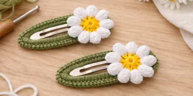Crochet snap hair clip with daisy flower made using beginner-friendly pattern on neutral background