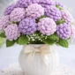 Easy crochet chrysanthemum flower in lilac color held in hand, perfect for home decor and handmade bouquet projects