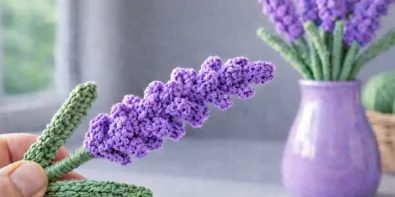 Easy crochet lavender flower held by hand with lavender bouquet in vase on soft blurred background