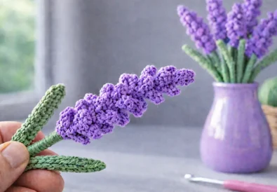 Easy crochet lavender flower held by hand with lavender bouquet in vase on soft blurred background