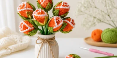 Easy crochet rosebud pattern made from a flat circle with orange yarn, white edge detail, green leafy base, and a handmade bouquet look.