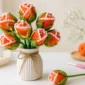 Easy crochet rosebud pattern made from a flat circle with orange yarn, white edge detail, green leafy base, and a handmade bouquet look.