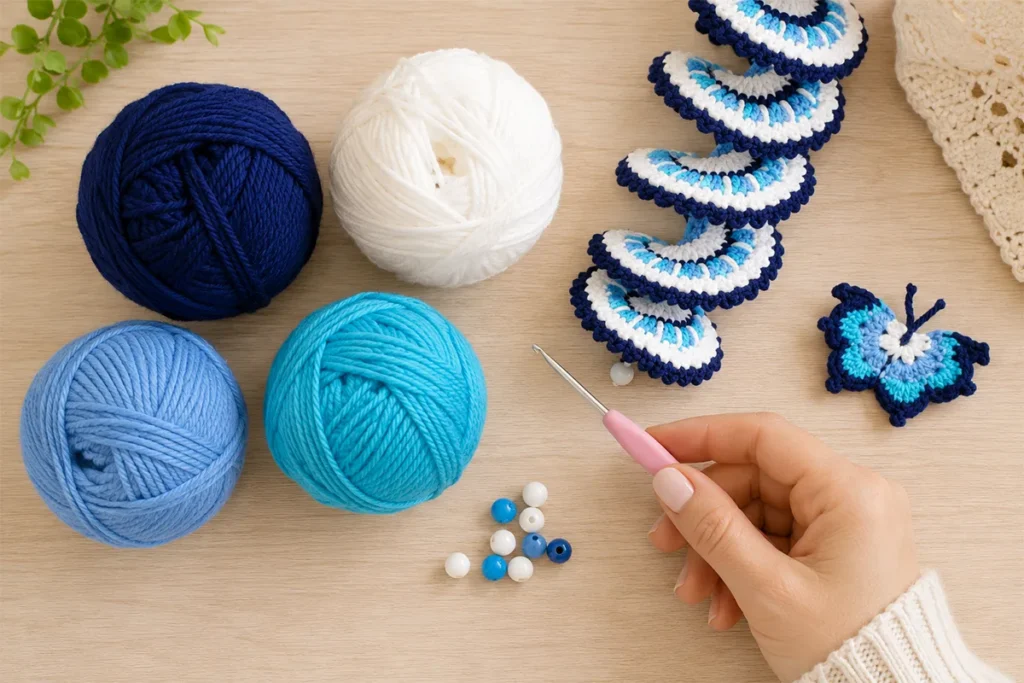 Materials for an easy crochet wind spinner with blue, white, turquoise yarn, beads, crochet hook, and butterfly detail