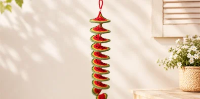 Crochet watermelon wind spinner featured image showing a finished spiral crochet decoration with a watermelon slice charm on a soft pastel craft table